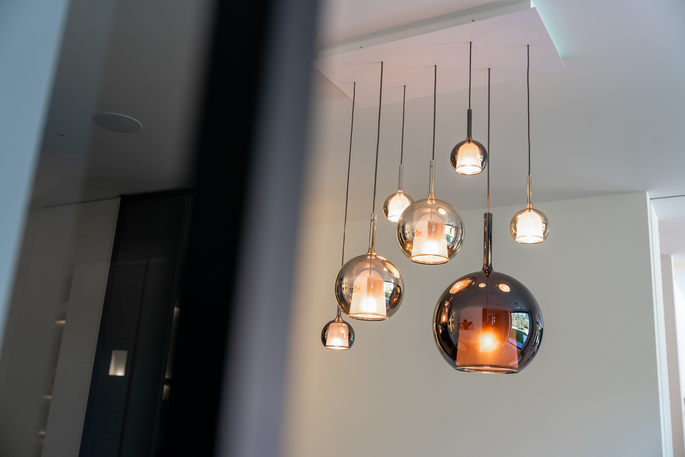 Ronde hanglampen van verschillende formaten worden aangestuurd door een centraal aangestuurd verlichtingssysteem.