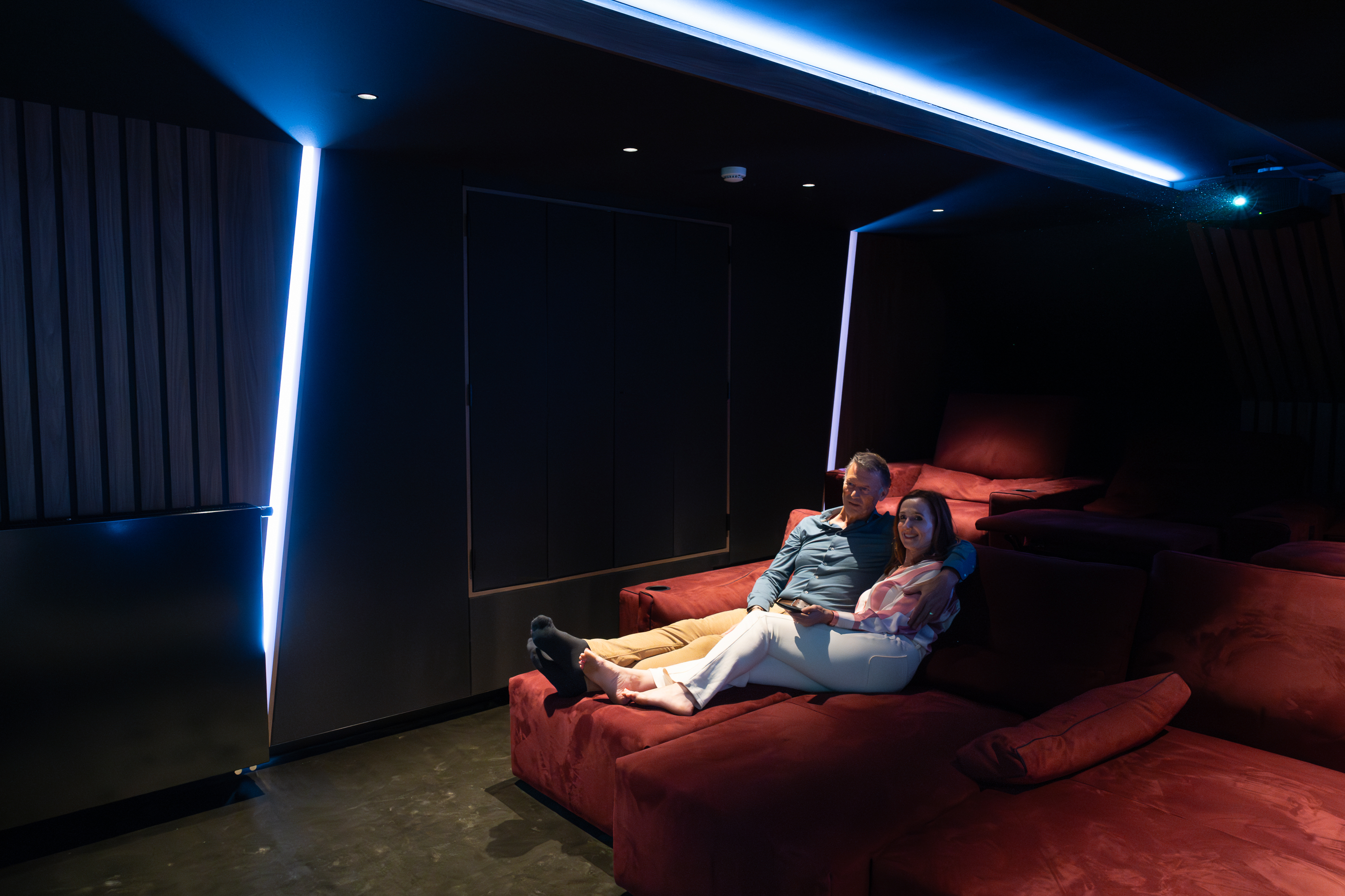 Een man en een vrouw ervaren het effect van een home cinema via een levensechte demo.