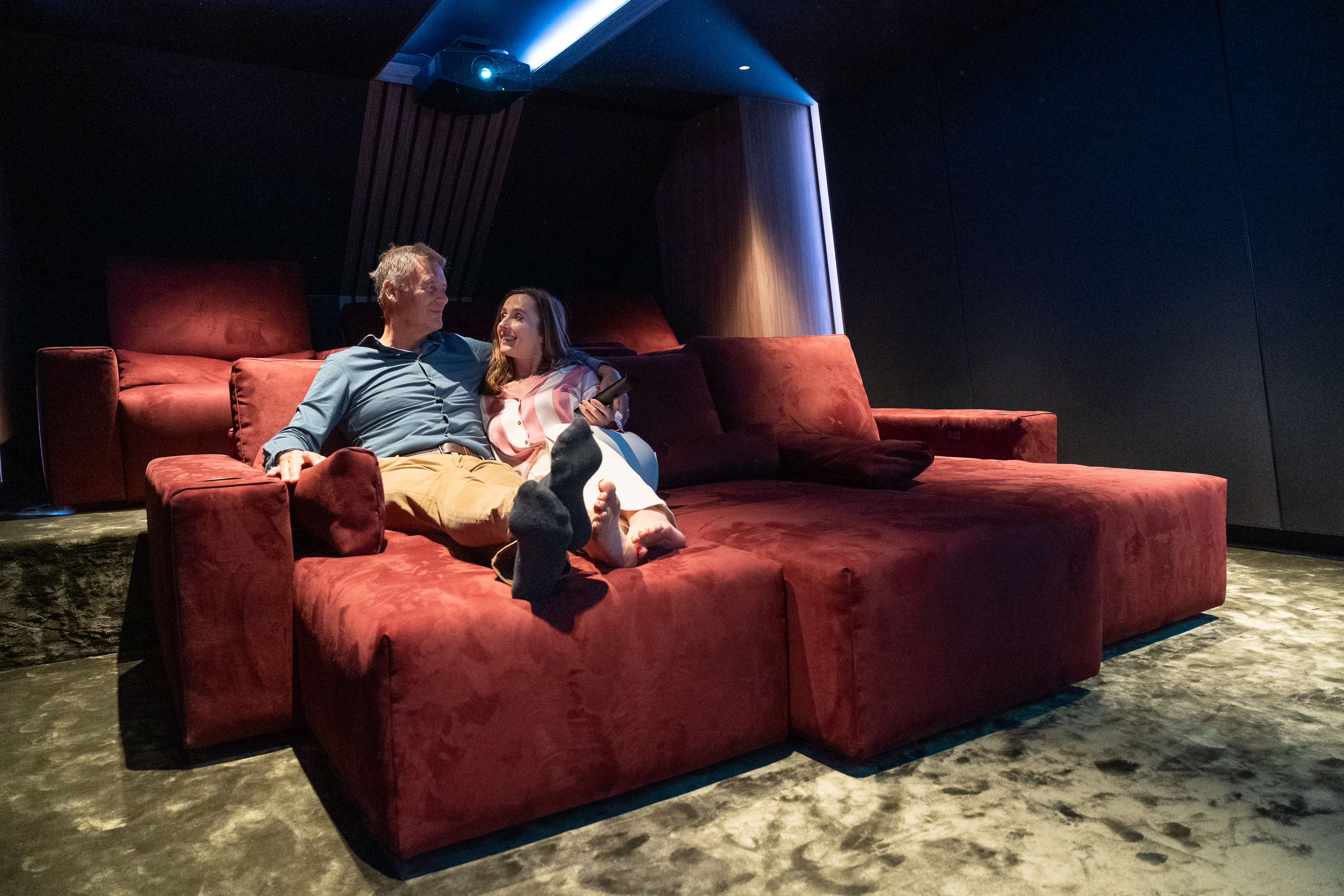 Een man en een vrouw maken kennis met het comfort van een home cinema.
